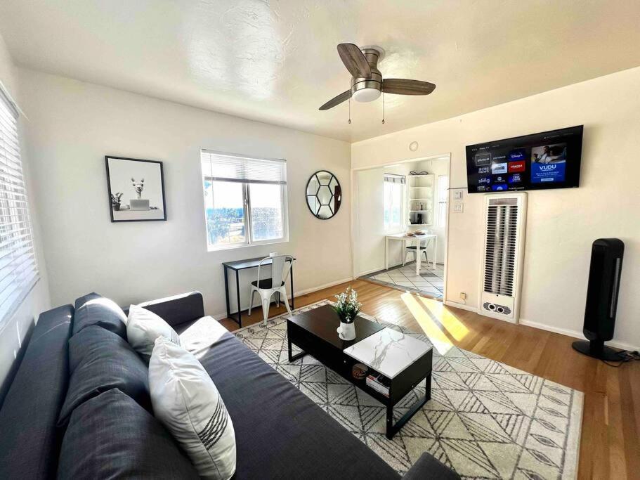 een woonkamer met een blauwe bank en een flatscreen-tv bij Minimalist 1 bed by Airport & Old Town in San Diego