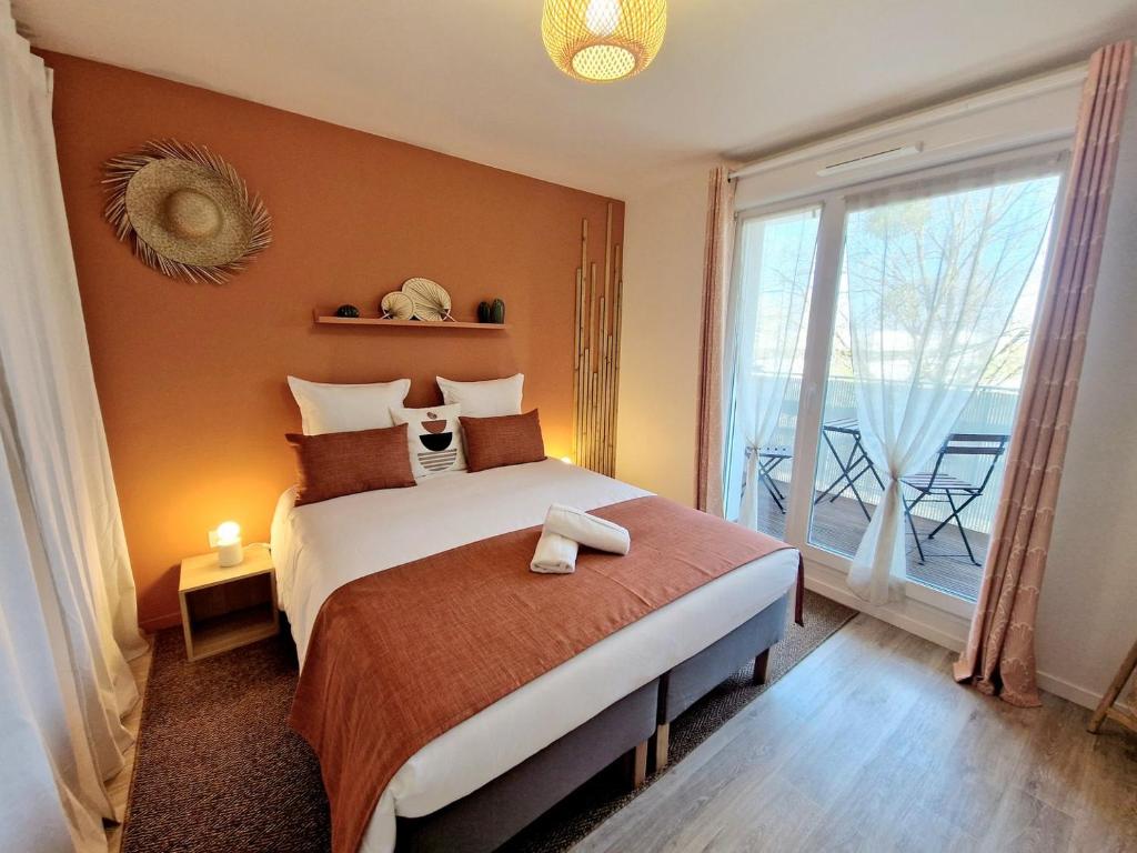 ein Schlafzimmer mit einem großen Bett und einem großen Fenster in der Unterkunft L'Hacienda / F2 de standing Cergy /parking inclus in Cergy