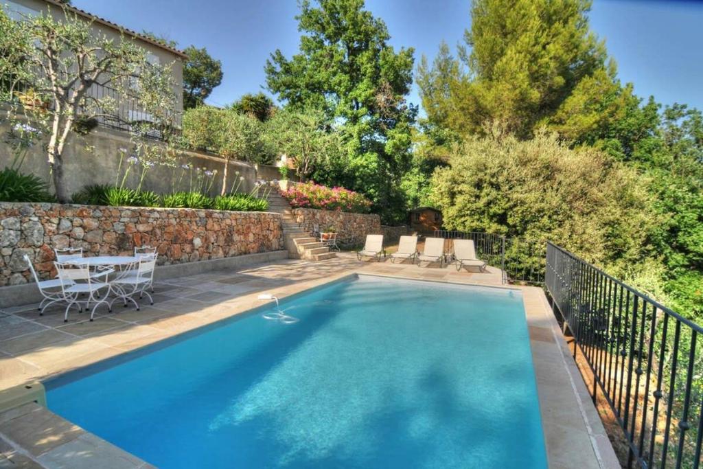 a swimming pool with a table and chairs in a yard at Luxury 3 bedroom villa with pool in Spéracèdes