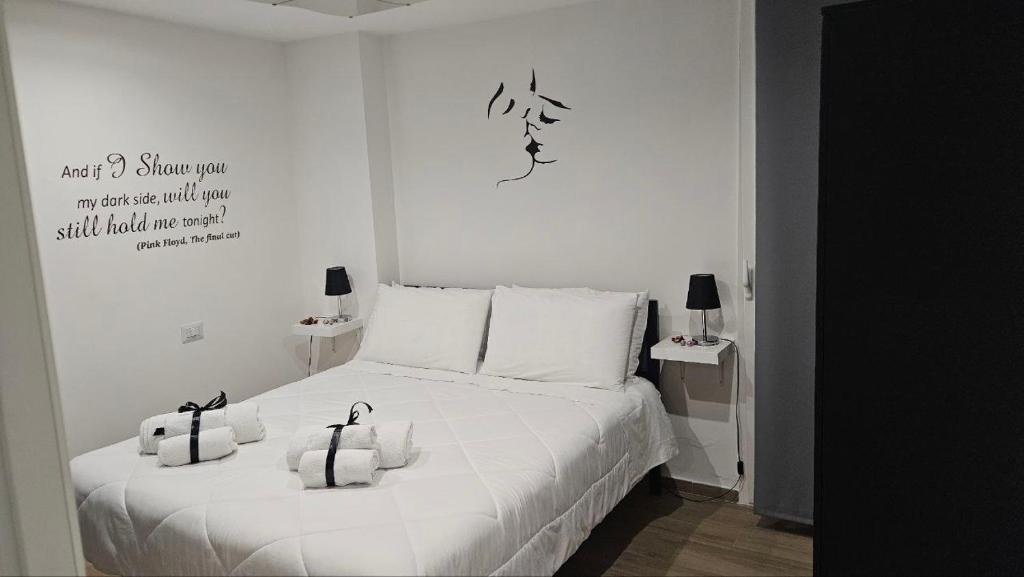 een slaapkamer met een wit bed met twee zakken erop bij Black & White Luxury Rooms in Bari