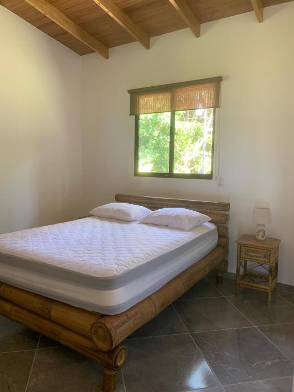 a bed in a bedroom with a window at Casa Tres Tucanes in San Isidro