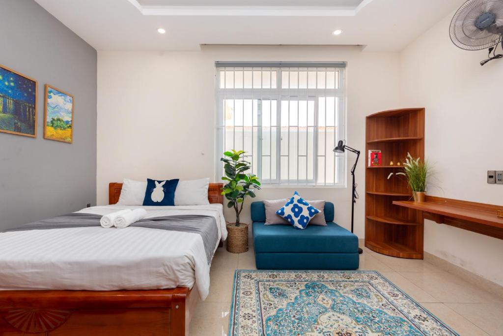 ein Schlafzimmer mit einem Bett und einem blauen Stuhl in der Unterkunft Prague Hotel Vung Tau in Vũng Tàu