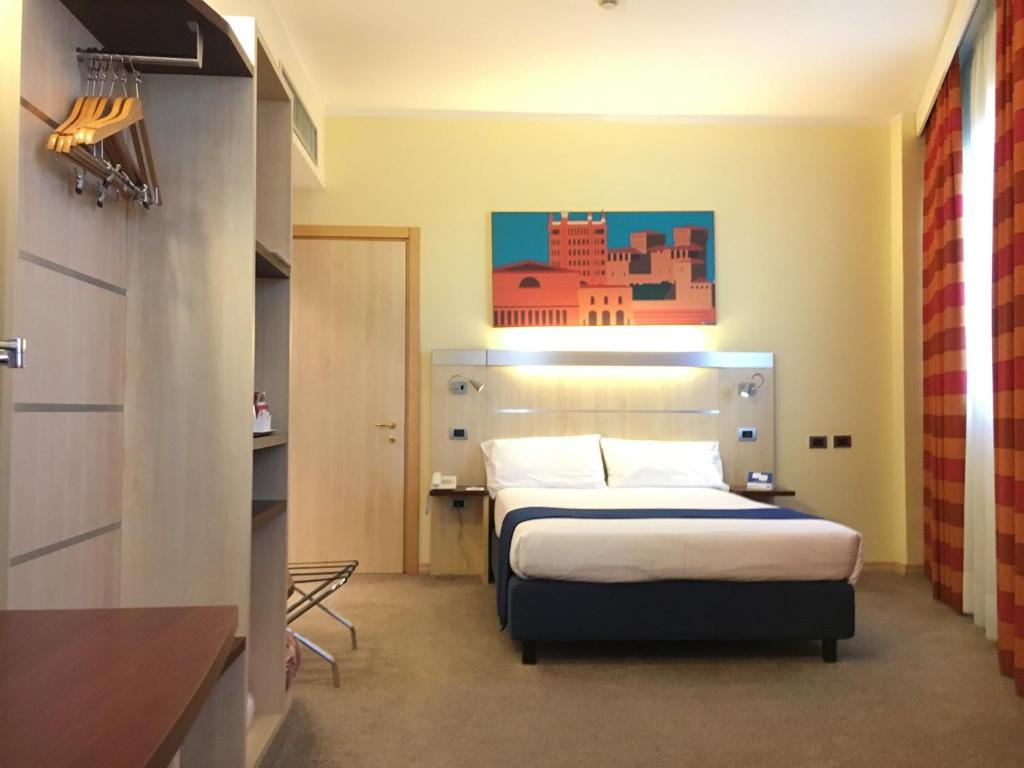 a hotel room with a bed and a kitchen at Holiday Inn Express Parma, an IHG Hotel in Parma