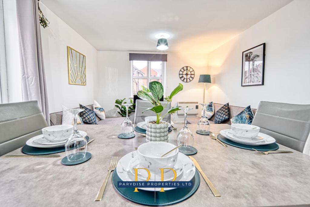 a dining room with a table with plates and glasses at The Sale Serendipity Suite - By Parydise Properties - Business or Leisure Stays - Sleeps 6 - Sale, Manchester in Sale