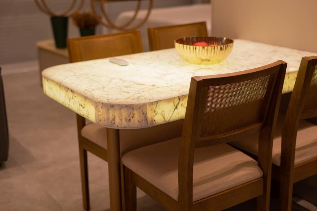 a marble table and chairs with a bowl on top at Apartamento Studio Hub Smart in Criciúma