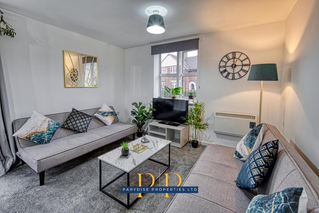 a living room with a couch and a tv at The Sale Symphony Suite - By Parydise Properties - Business or Leisure Stays - Sleeps 6 - Sale, Manchester in Sale