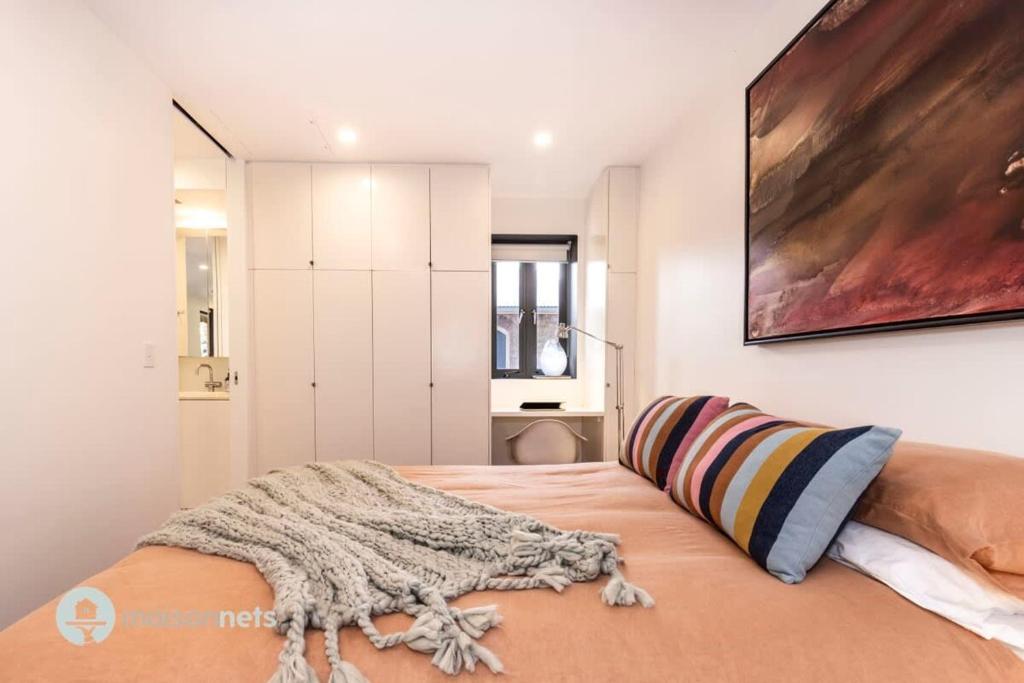 a bedroom with a bed with a blanket on it at Darlinghurst Apt W A C Balcony Only A Walk To CBD in Sydney
