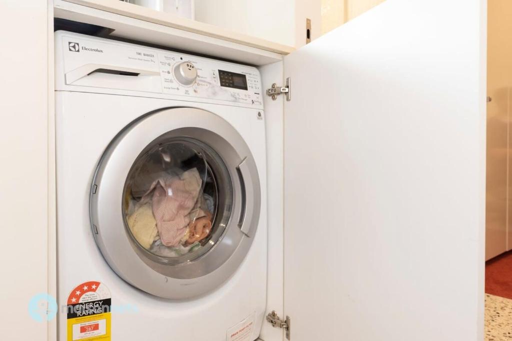 a white washing machine in a white room at Darlinghurst Apt W A C Balcony Only A Walk To CBD in Sydney