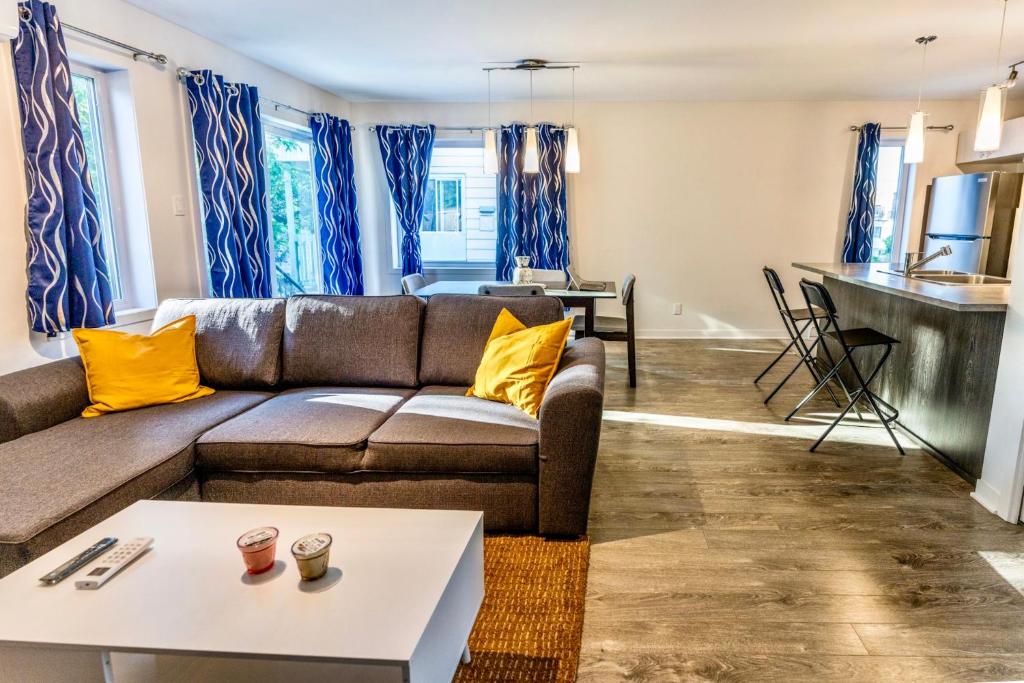 sala de estar con sofá y mesa en Appartment 2BR 4 beds AC wi-Fi Smart TV FreeParking, en Laval