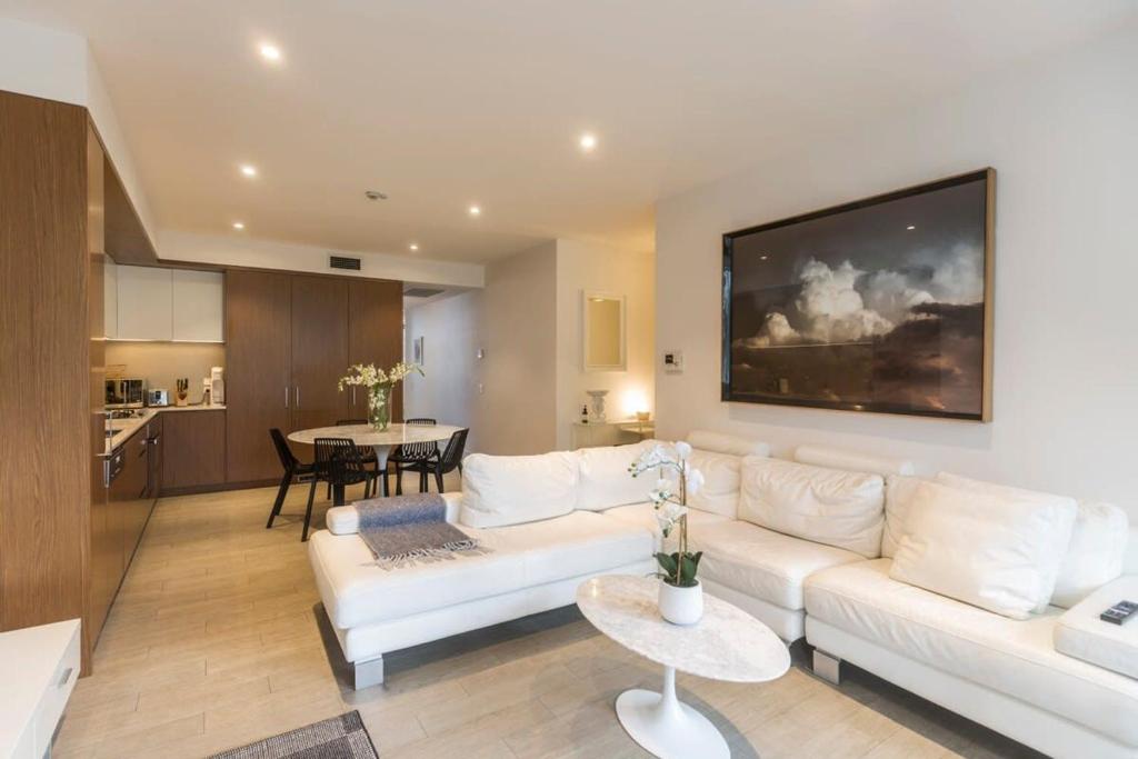 Una sala de estar con un sofá blanco y una mesa. en Luxurious Spacious OneBed Apt close to Bondi Beach, en Sídney