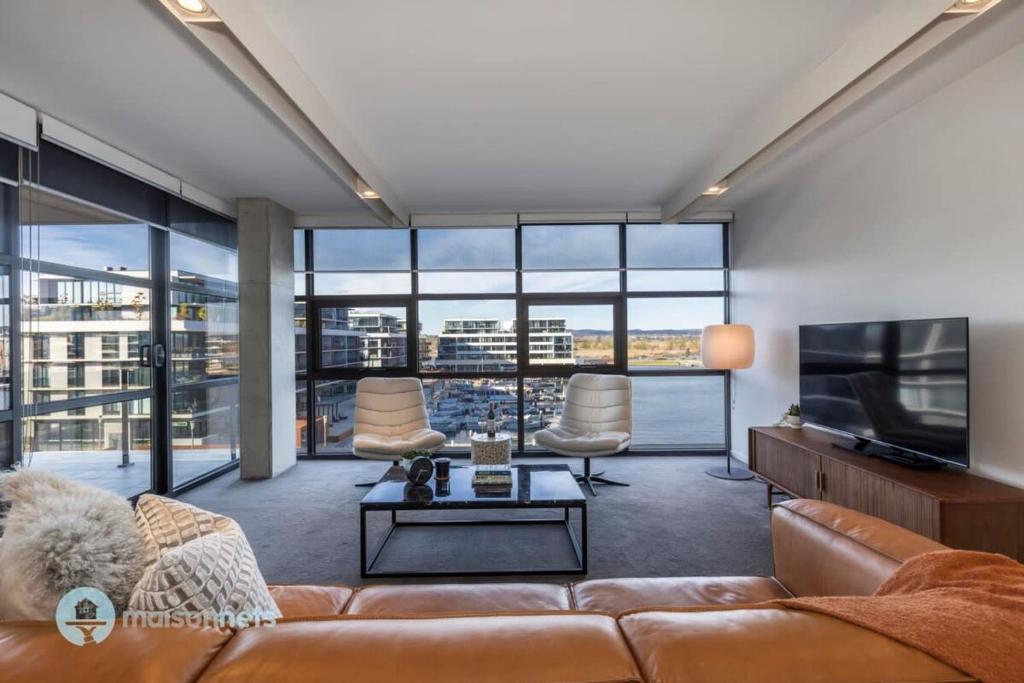 sala de estar con sofá y TV en Modern 2 Bdrm Apt with Water Views 2x Car Spots en Canberra