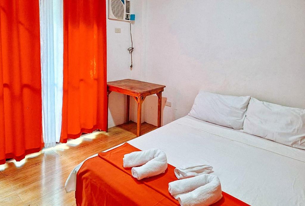 - une chambre avec un lit et des serviettes dans l'établissement RedDoorz @ Hergem Siargao Inn, à General Luna