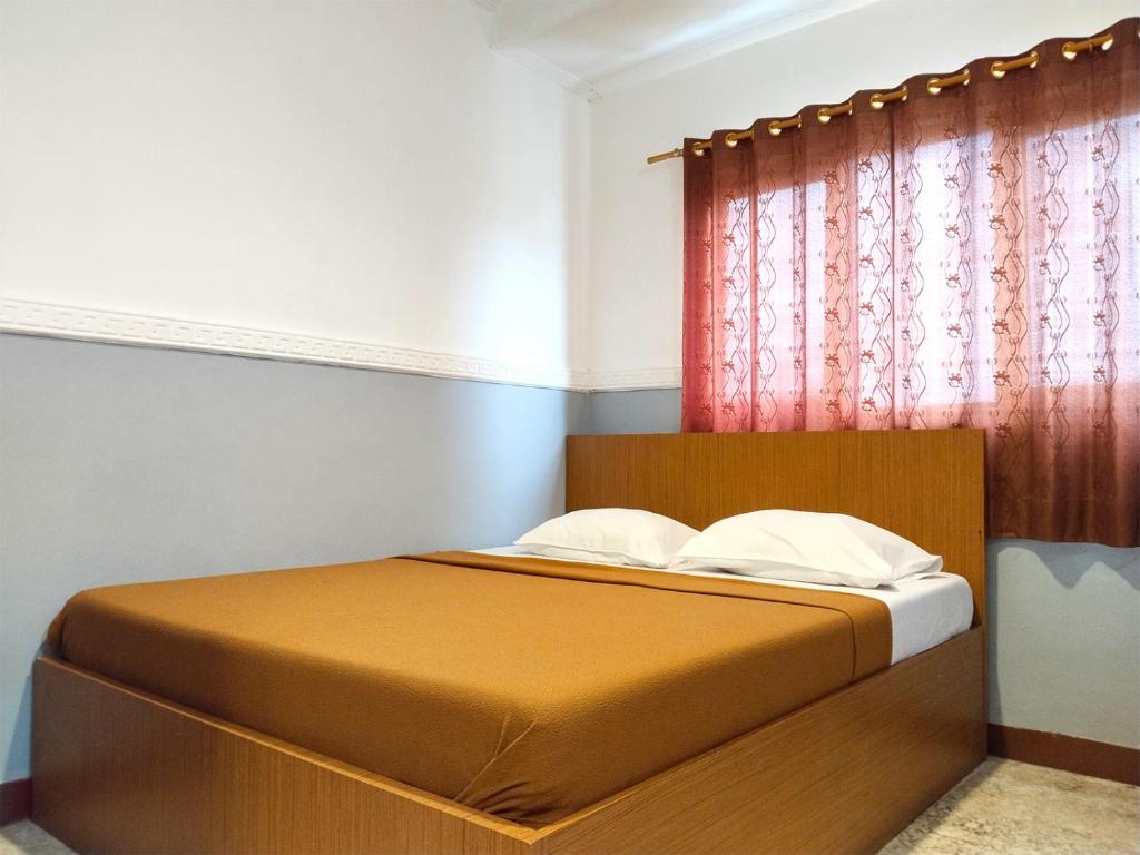 雅加達的住宿－Wisma Juanda Powered by Cocotel，卧室内的一张床位,卧室设有红色窗户