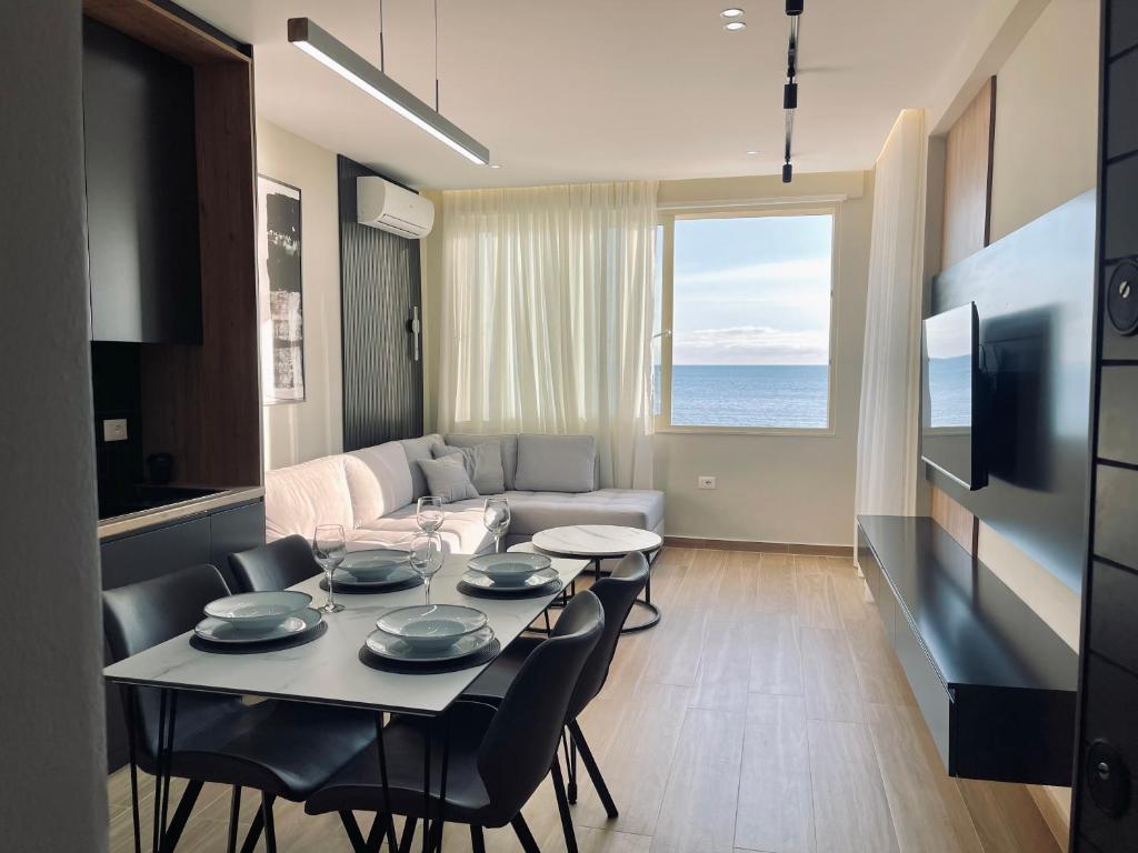 een woonkamer met een tafel en stoelen en een bank bij Luxurious Dreamy seaview apartment in Durrës