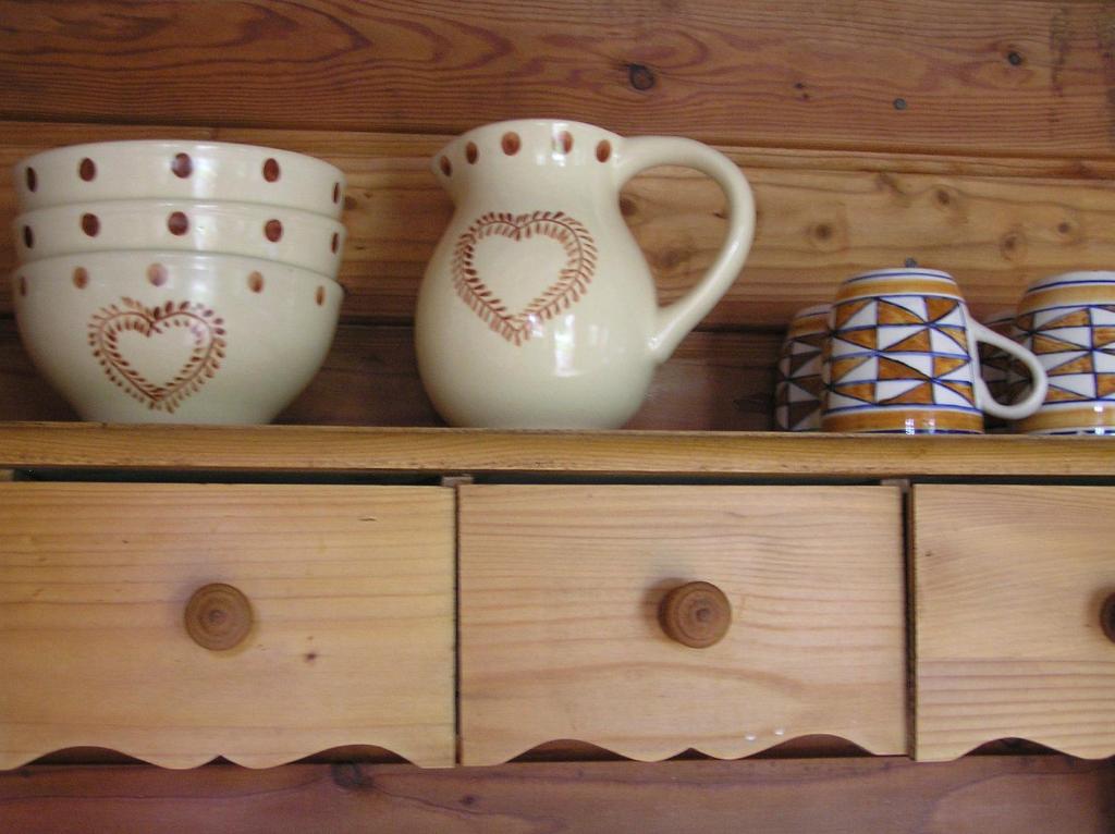 Un estante con tres jarrones y tazas. en Residences Du Golf Des Roucous, en Sauveterre
