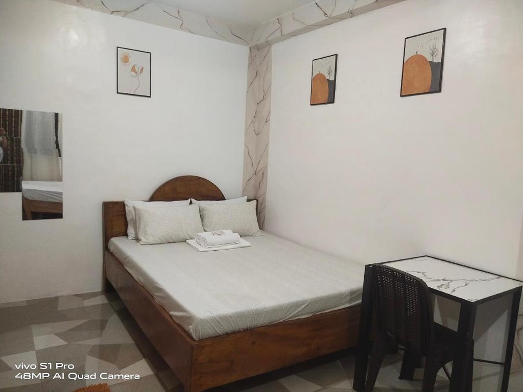ein kleines Bett in einem Zimmer mit einem Tisch in der Unterkunft Catmel Lodging House in Romblon