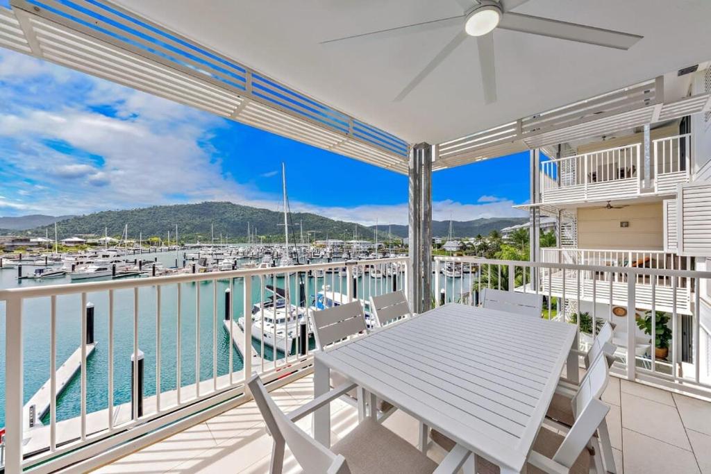 a balcony with a table and chairs and a marina at Marina Living with views and more in Airlie Beach