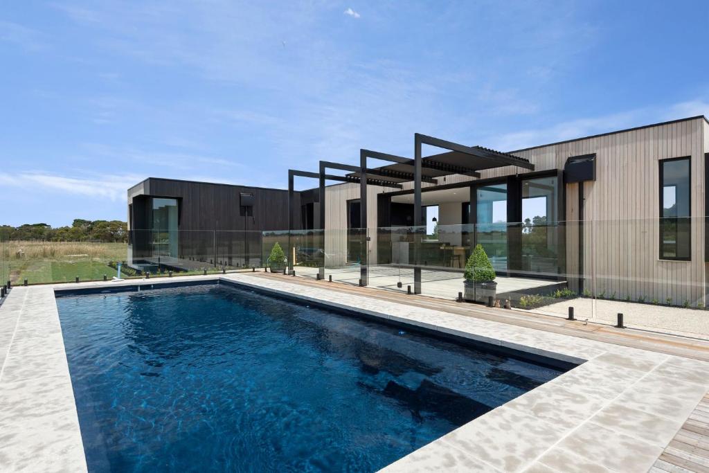 a house with a swimming pool in front of it at Curlewis Farm in Curlewis
