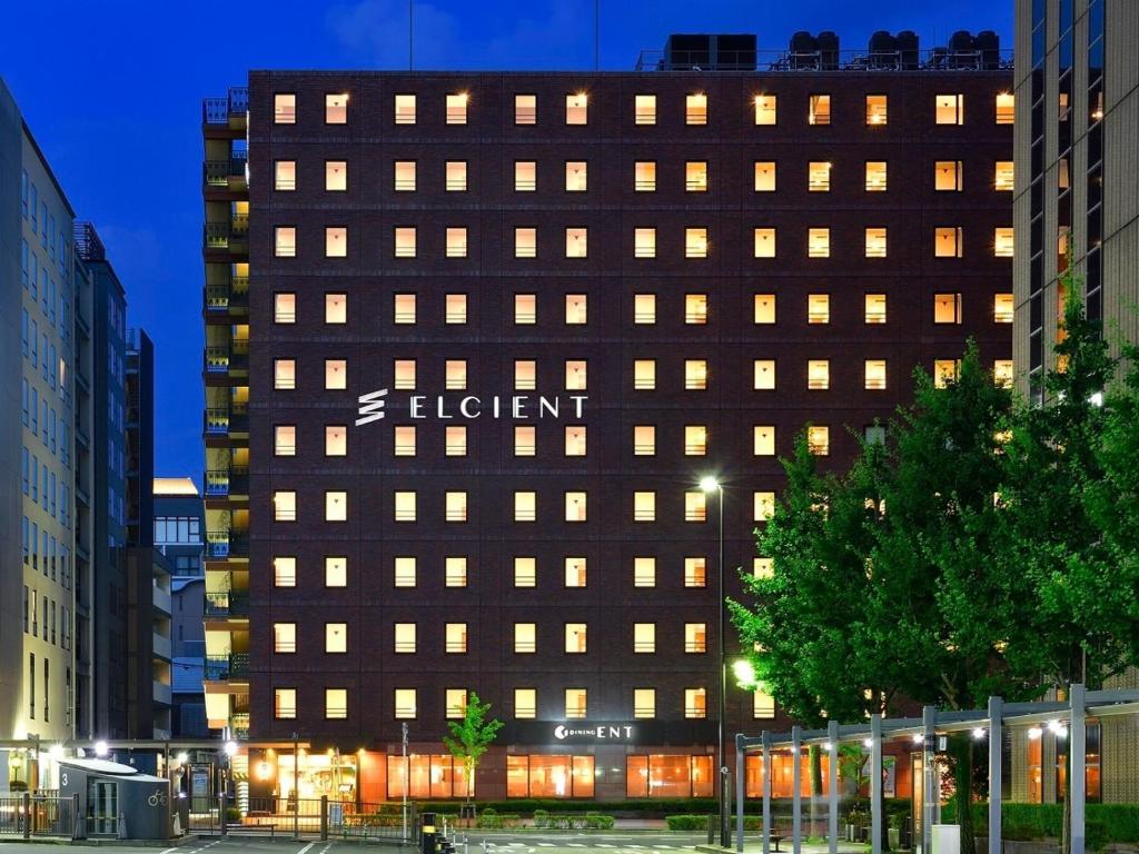 un bâtiment brun avec un panneau sur son côté dans l'établissement Hotel Elcient Kyoto Hachijoguchi, à Kyoto