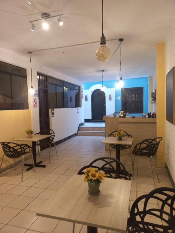 una habitación con mesas y sillas y una cocina en El Boquerón - Hospedaje en Huanchaco
