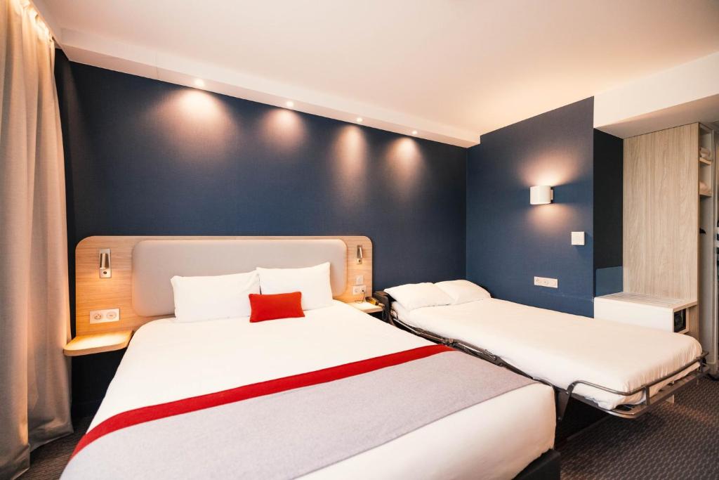 two beds in a room with blue walls at Holiday Inn Express - Paris - CDG Airport by IHG in Roissy-en-France