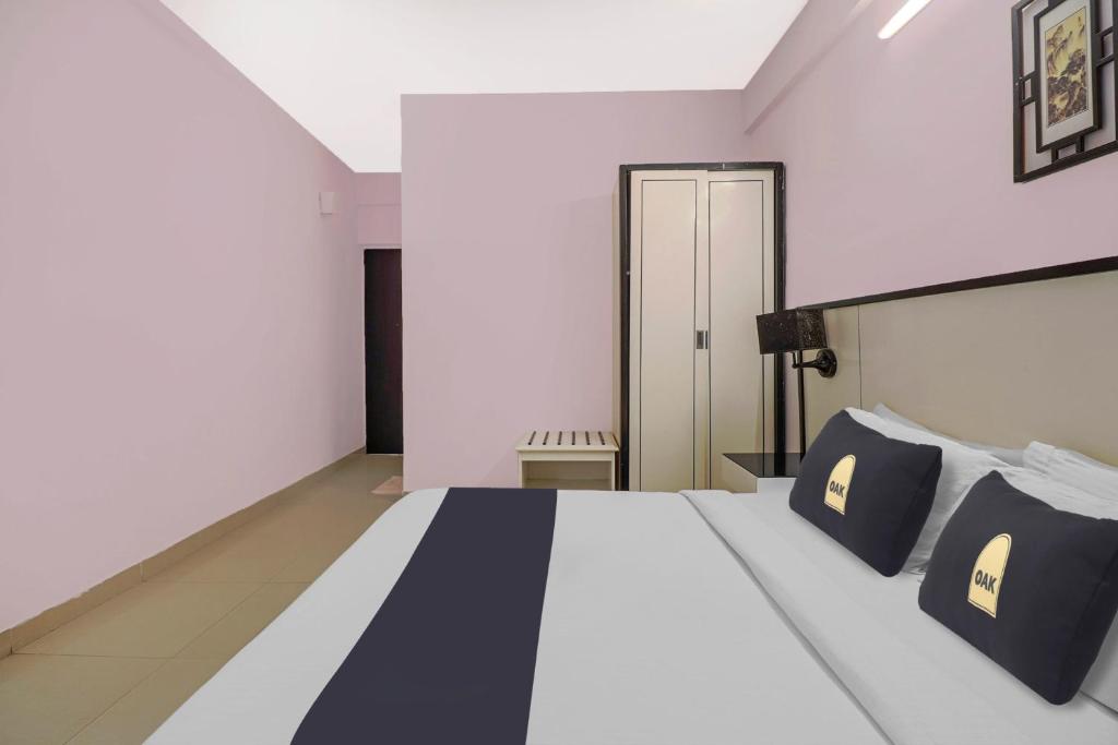 Collection O Hotel 29 Church's Inn Near Cubbon Park في بانغالور: غرفة نوم مع سرير مع وسائد سوداء وبيضاء