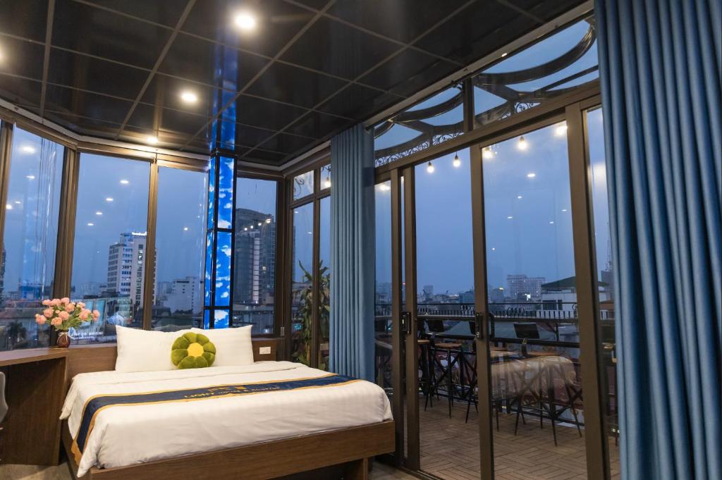 1 dormitorio con 1 cama y balcón con ventanas en Light House & Rooftop en Hanoi