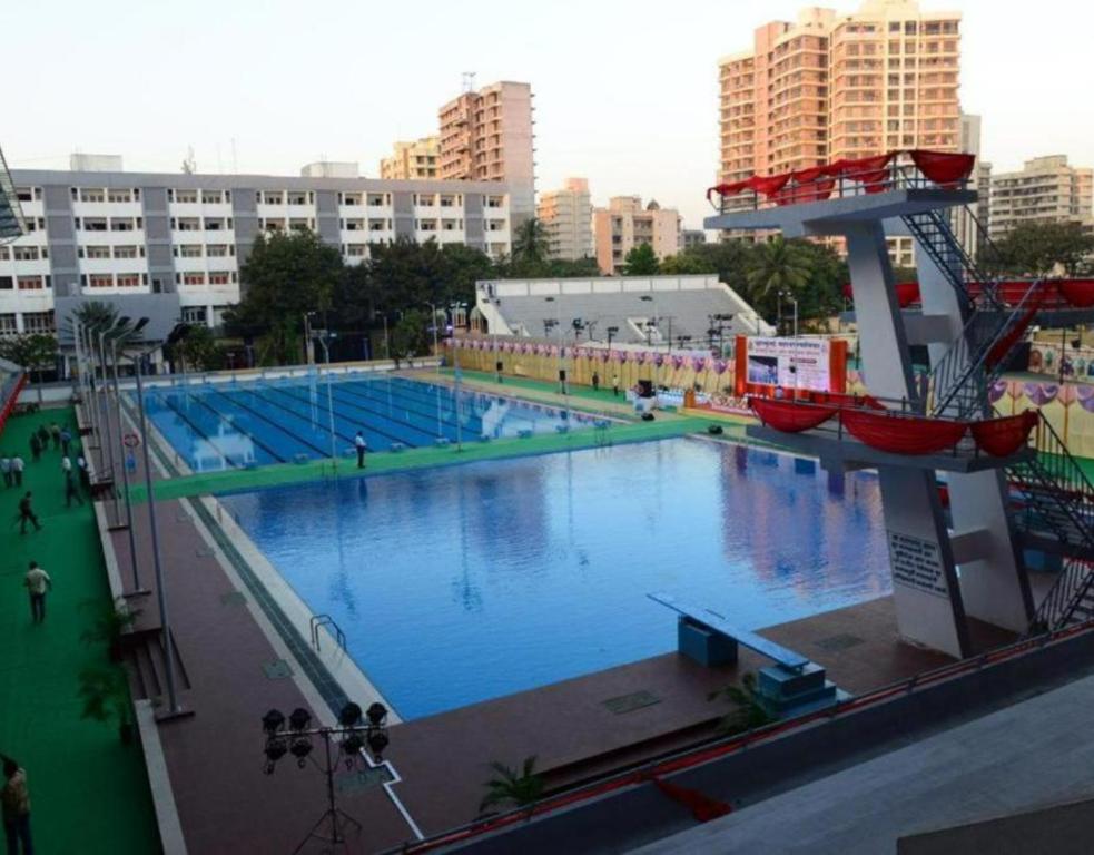 a large swimming pool in a city with tall buildings at Country Inn & Suites By Umrb - Mumbai International Airport in Mumbai