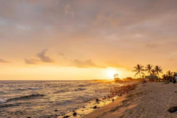un grupo de personas en una playa con una puesta de sol en UNIT C - Sandy Toes Getaway in Kona, en Kailua-Kona