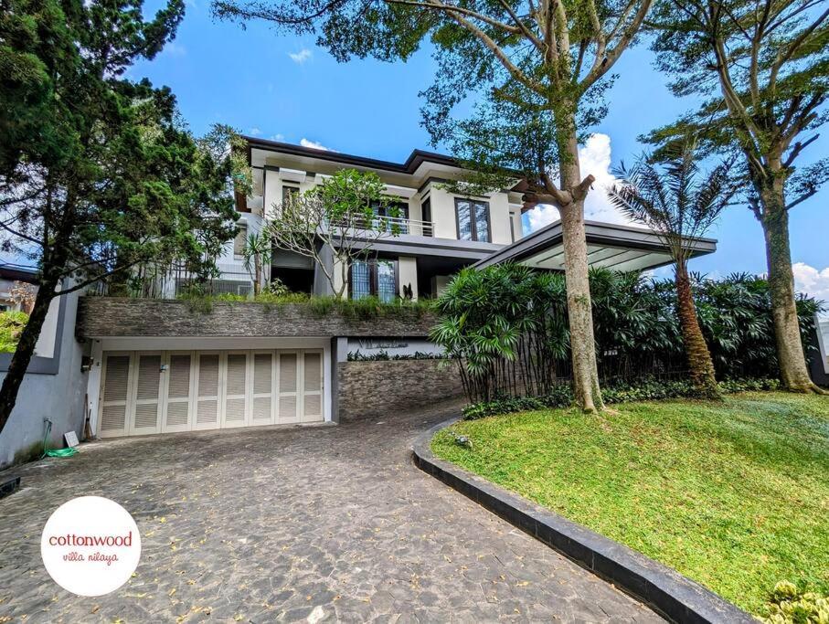 a house with a driveway and a garage at Cottonwood Villa Mewah Nilaya @Dago - BBQ Pingpong in Bandung