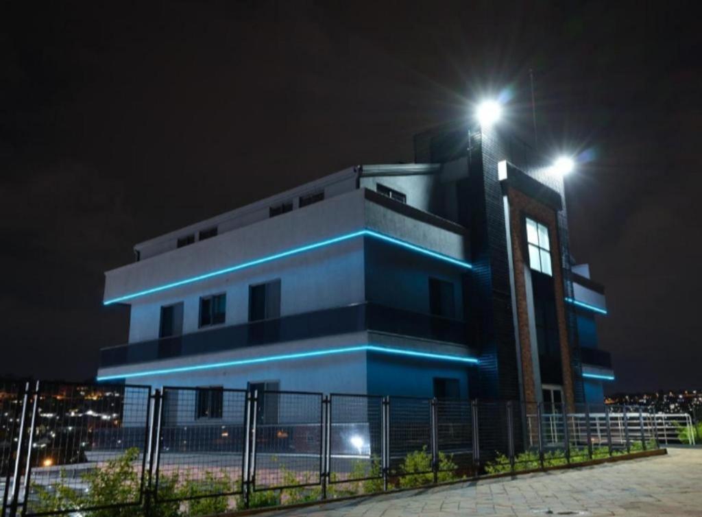 un bâtiment avec des lumières au-dessus de celui-ci la nuit dans l'établissement ACACUS LUXURY, à Kigali