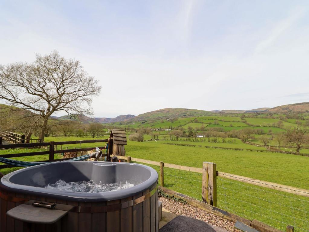 a bath tub with a view of a field at The Retreat in Oswestry