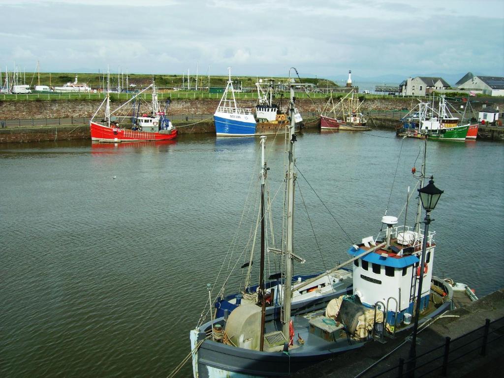 a boat is docked in a harbor with other boats at Harbour Side in Maryport