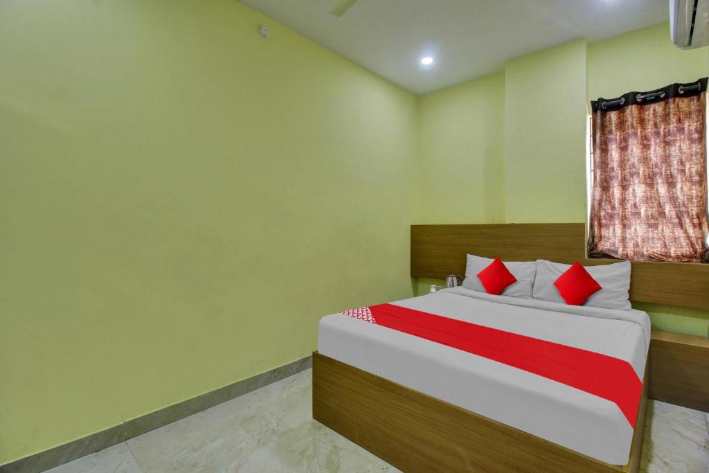 a bedroom with a bed with red and white pillows at Flagship Hotel Abhi's R Square Near Hayathnagar in Pedda Ambarpet