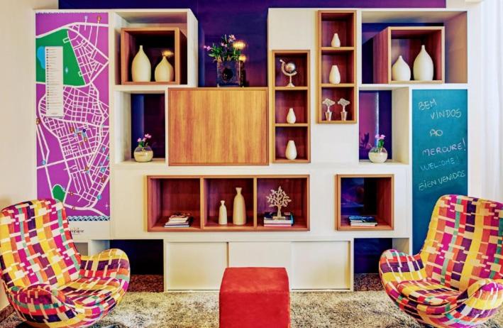 une chambre avec deux chaises et une étagère avec des vases dans l'établissement Hotel M-RCURE Vila Olímpia - The Best Smart Urban Duplex - Executive Edition - By LuXXoR, à São Paulo
