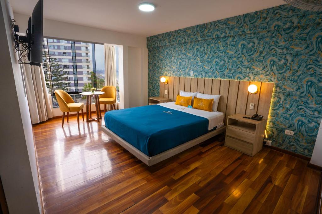 1 dormitorio con 1 cama, mesa y sillas en Golden Mar Hotel, en Lima