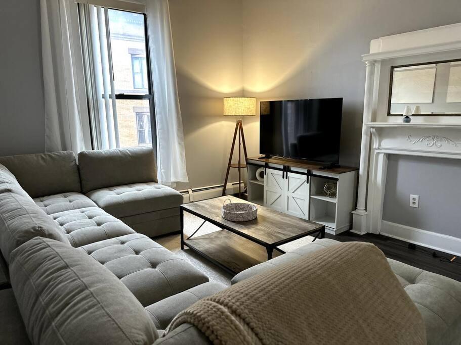 ein Wohnzimmer mit einem Sofa und einem TV in der Unterkunft Cozy Downtown Oasis in Hartford