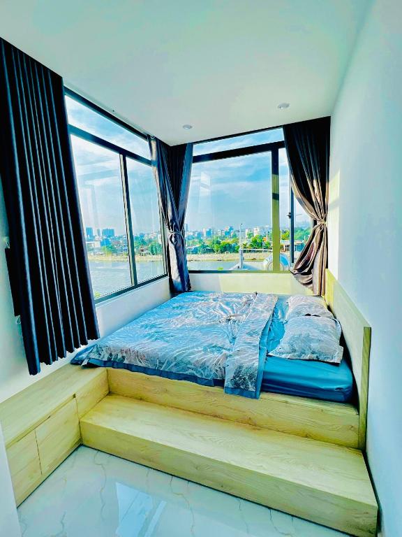 Bett in einem Zimmer mit einem großen Fenster in der Unterkunft Villa Quy Nhơn Gần Biển Gần Trung Tâm - Biệt Thự Quy Nhơn Gần Biển in Quy Nhon