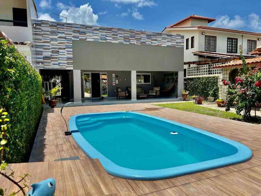 ein großer blauer Swimmingpool vor einem Haus in der Unterkunft Casa Itamaracá in Itamaracá