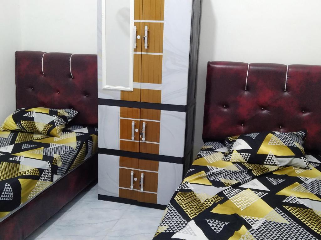 een slaapkamer met 2 bedden en een dressoir bij Home stay & Kost syariah SONY CA E.15 in Batu Hampar