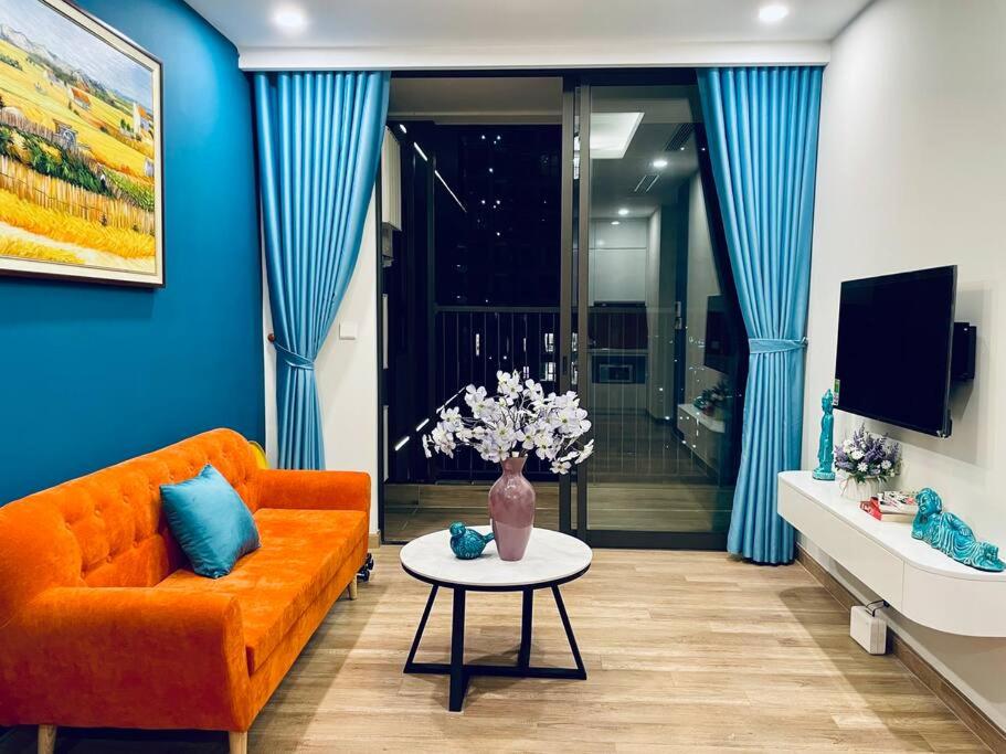 uma sala de estar com um sofá laranja e uma mesa em Elite House, Ecopark Swanlake _ Onsen, view Hồ Thiên Nga em HÆ°ng YÃªn