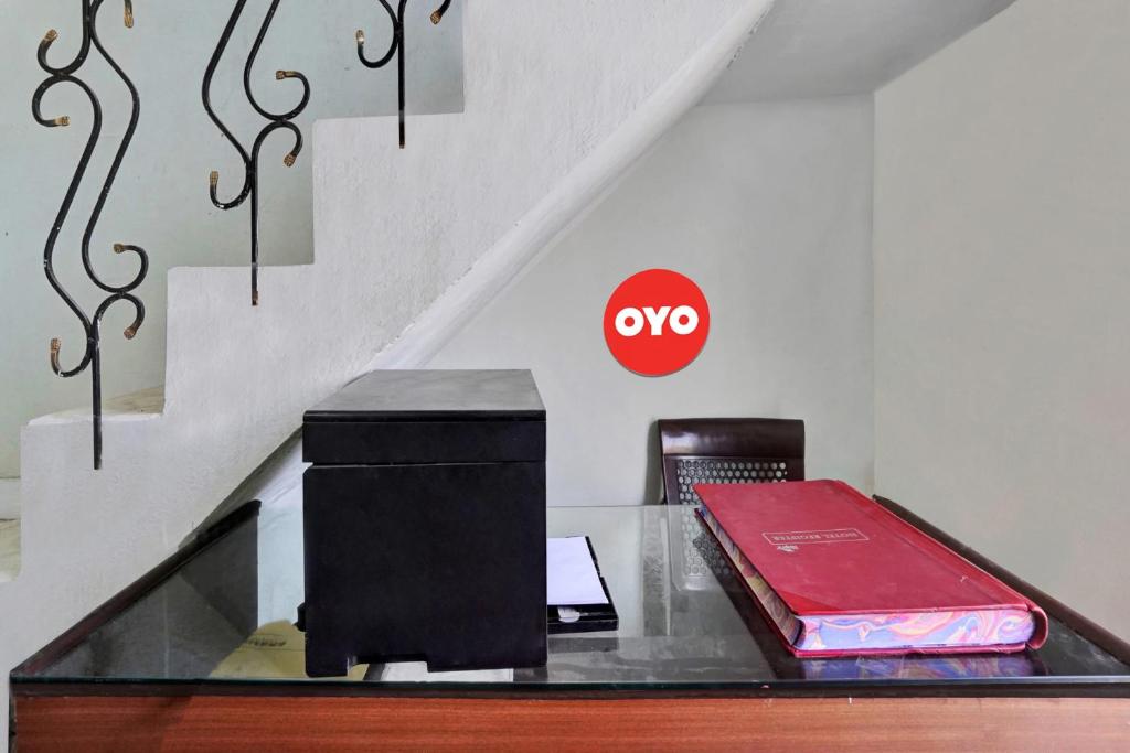 une table en verre avec un panneau rouge sans signe sur les escaliers dans l'établissement OYO Flagship Amazing Inn, à Murādnagar