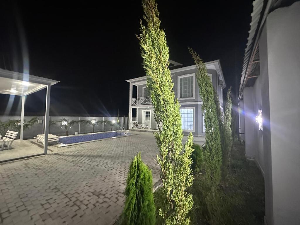 een wit huis 's nachts met een patio bij Gabala Modern Harmony in Gabala