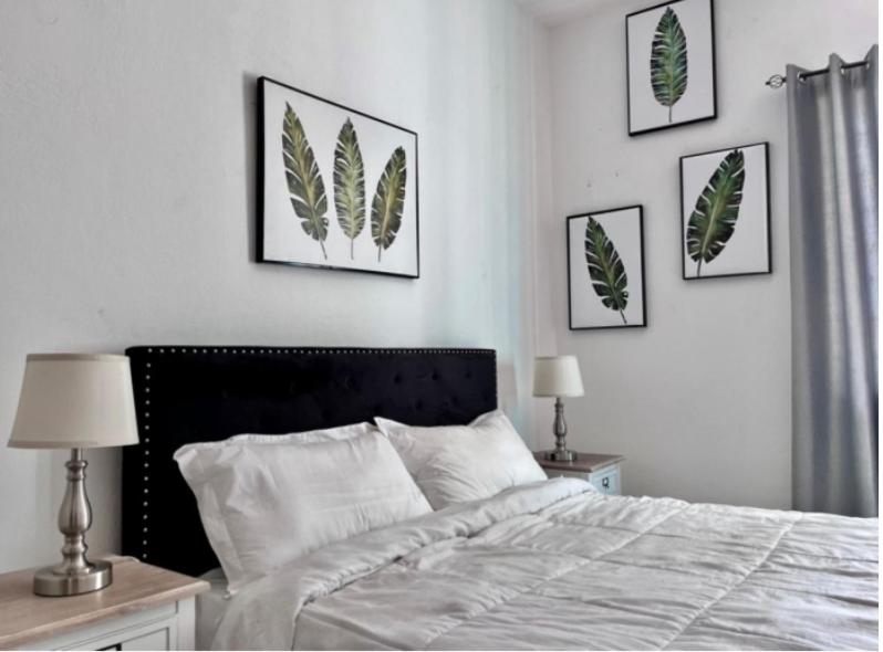 een slaapkamer met een bed met vier foto's aan de muur bij Beresford boutique in Kingston