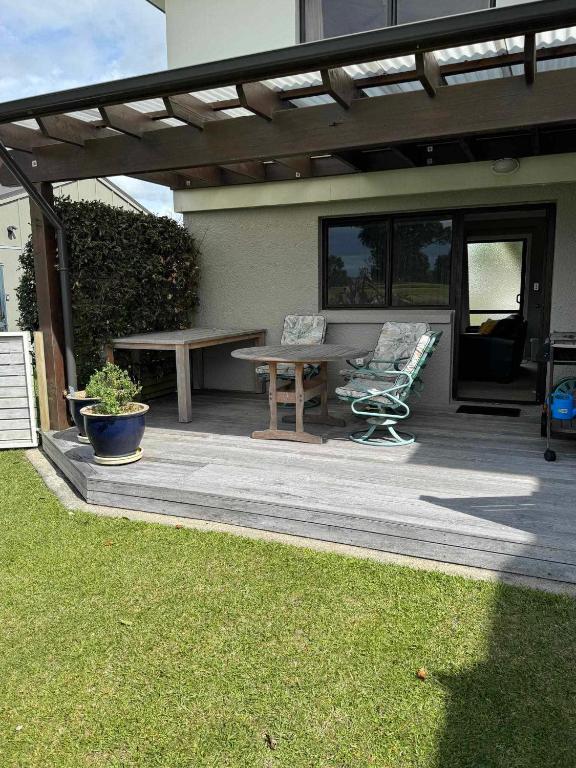 a patio with a picnic table and a bench at Coastal Golf & Spa Guesthouse in Mount Maunganui