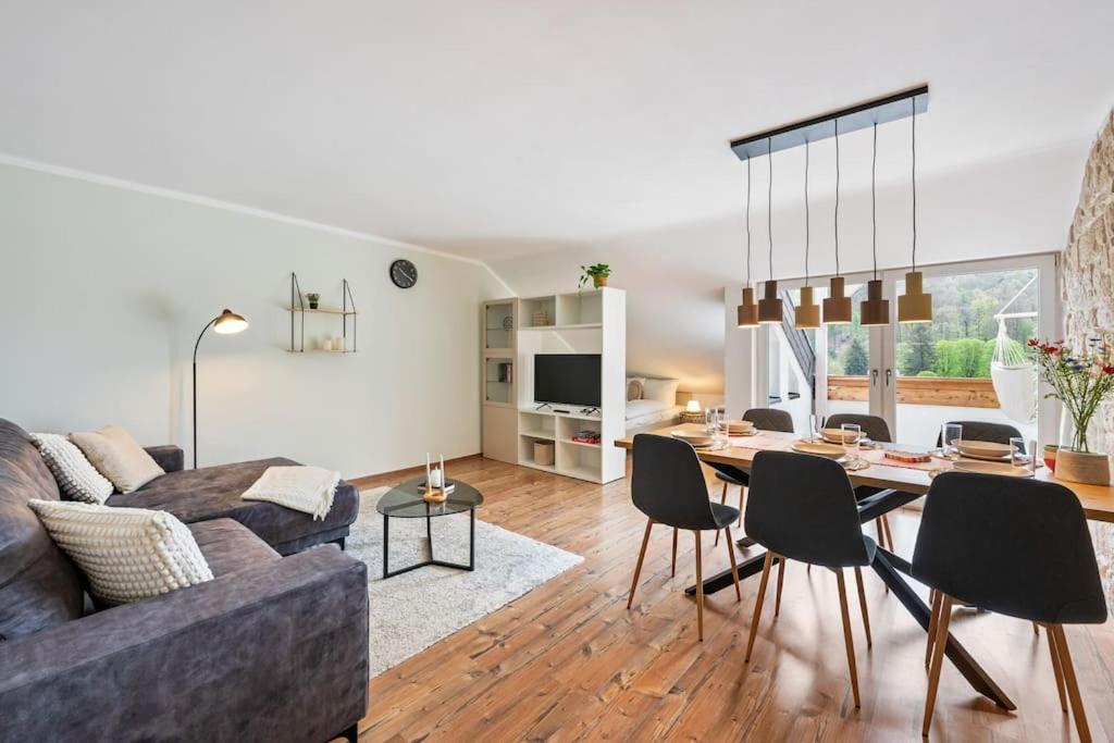 sala de estar con sofá y mesa con sillas en Traumhafte Wohnung mit Neckarblick en Neckarsteinach