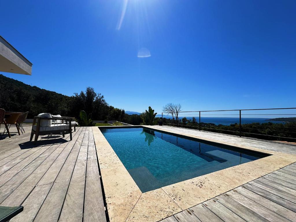 a swimming pool on a deck with a view of the ocean at Villas de standing avec magnifique vue mer et piscines privées, Sagone in Sagone