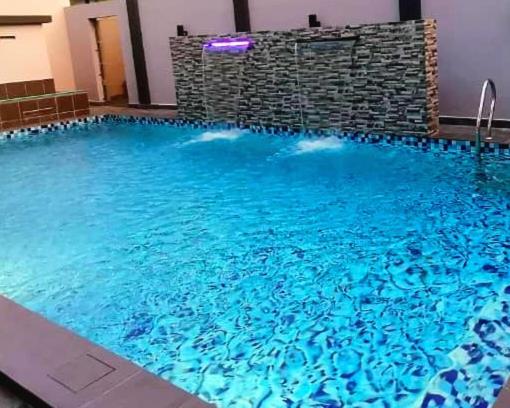 uma grande piscina com água azul num edifício em The Blue Residence em Kuah