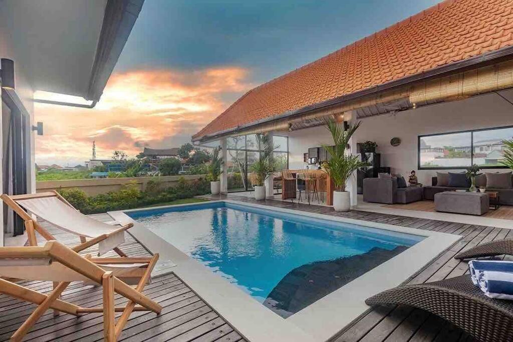 einen Pool im Hinterhof mit einem Haus in der Unterkunft New 3BR villa,Sunset &ricefield views Canggu area! in Kerobokan