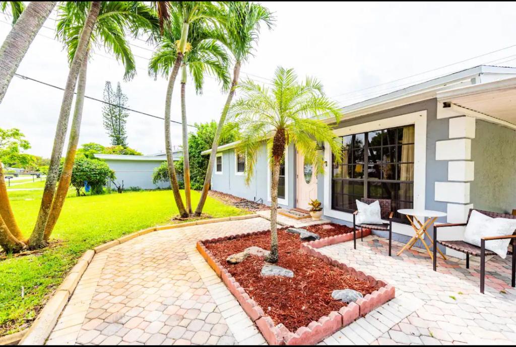 a house with palm trees and a patio at Philllips Tropical Paradise in Fort Lauderdale
